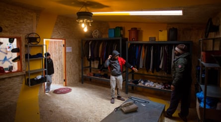 Refugees try on clothes in the men's clothing store at the Katsikas refugee camp in Greece