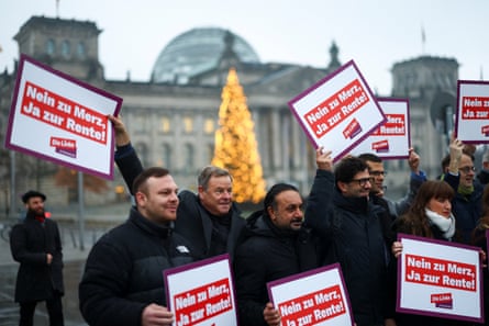 Die Linke party members hold signs reading ‘No to Merz, Yes to pensions’ at a protest in front of the Reichstag in Berlin on 5 December.