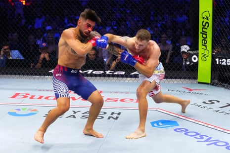 Justin Gaethje of the US strikes Ilia Topuria of Spain during their UFC lightweight championship fight on the White House South Lawn.