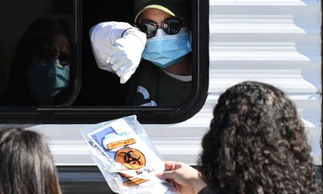 Two women receive a testing kit at a walk-up site in Los Angeles. The CDC director, Robert Redfield, warned that America was ‘at a very critical time right now’.