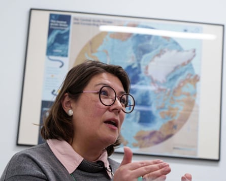Olsvig with map behind speaking in her office on 16 January
