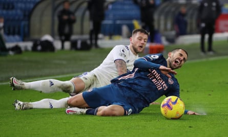Dani Ceballos goes down under a challenge from Leeds' Liam Cooper.