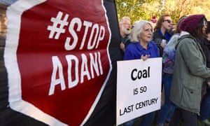 Protesters in Canberra hold banners against Adani