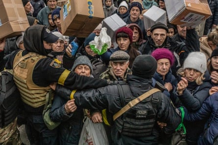 Kherson residents crowd around a volunteer aid truck to receive food