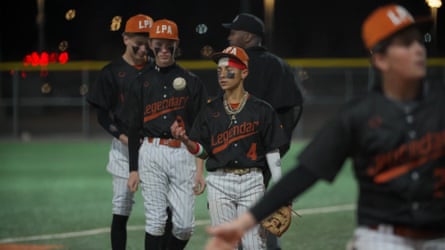 Players from the Legendary Performance Academy warm up before a game, one casually tossing a baseball as teammates look on.
