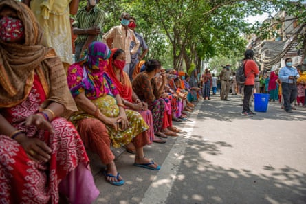 women in colourful garments sitting down on a street in India