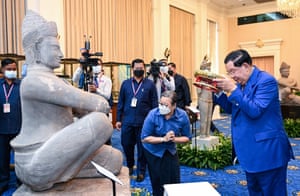 Phnom Penh, Cambodia. Cambodia’s prime minister, Hun Sen, prays in front of a statue