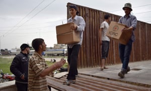 Workers from the Red Crescent and International Committee of the Red Cross unload relief supplies in Rastan, north of the central Syrian city of Homs