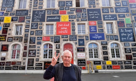 Ben in front of the “Wall of Words”, a public order inaugurated in 1995 consisting of 313 retrospective enamel plaques of Ben’s writing paintings, at the Fondation du Doute in Blois, in 2022.