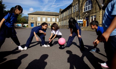 Children play with a ball in a school playground
