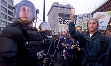 A protester makes a peace sign in front of a police officer in Seattle in 1999 during the protests surrounding the WTO conference.