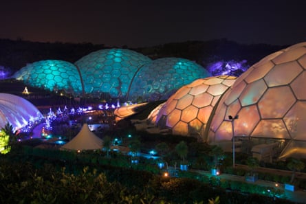 The geodesic domes of the Eden Project colourfully lit at night.