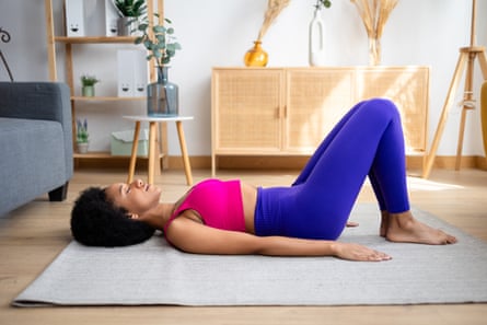 Young woman lying on a mat in exercise gear.