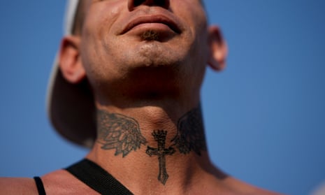 A man with a cross tattoo on his neck