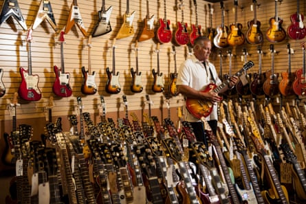 Harris in his store surrounded by guitars.