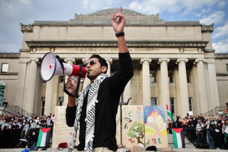 a man speaks into a megaphone on a university campus