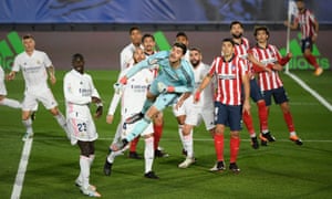 Real Madrid’s Thibaut Courtois punches clear in a crowded box