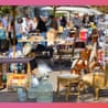 Outdoor flea market with tables of antiques, birdcages, chairs, and a mannequin form