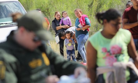 Central American asylum seekers wait as US border patrol agents take them into custody on 12 June 2018 near McAllen, Texas.