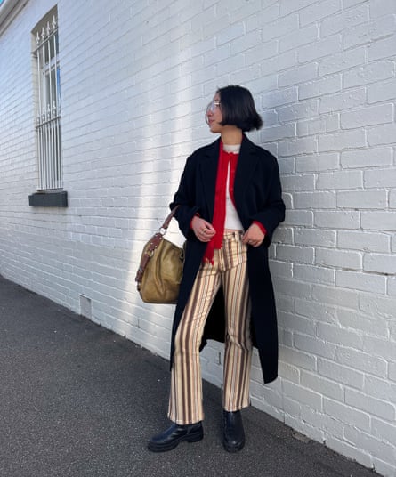 Maggie Zhou bundles a red cardigan and scarf under her coat for a workday look.