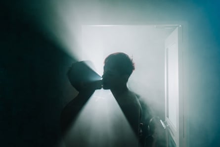 Two figures are silhouetted against lit mist as they appear to lean in for a kiss