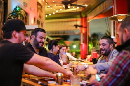 Chef José Mendín and Maximo Silva play dominoes at La Placita, Mendín’s restaurant in Miami.