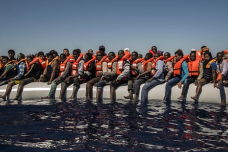 Migrants from Eritrea, Mali, Bangladesh and other countries wait to be rescued, off the coast of Libya