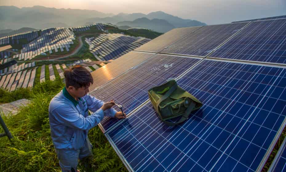 A worker maintains photo-voltaic panels