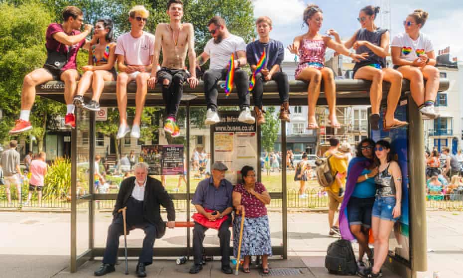 Young and old people wait for a bus after Brighton's Pride parade