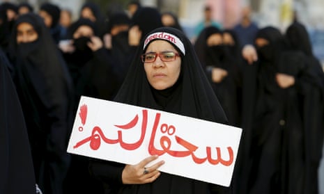 Protester holds a banner saying “to hell with you” as she takes part in a protest against the execution of Saudi Shia cleric Nimr al-Nimr by Saudi authorities, in the village of Sanabis.<br>