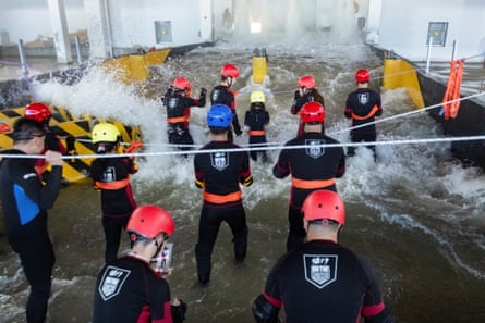 Participants brace for surging water in a flash flood simulator at the Lvxing centre in Hangzhou.