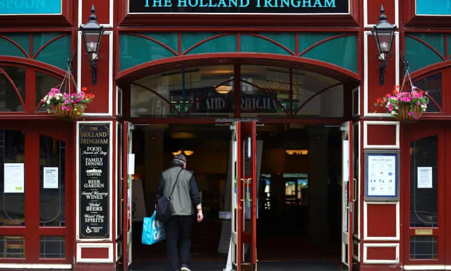 A customer enters the Holland Tringham Wetherspoons pub in London.