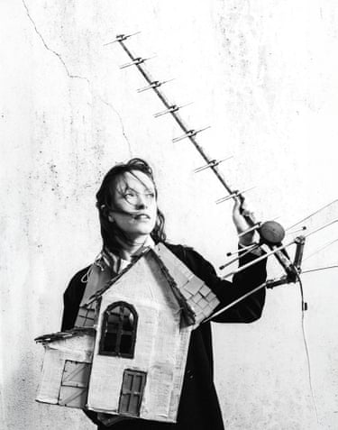 A person holding a paper house and large antenna