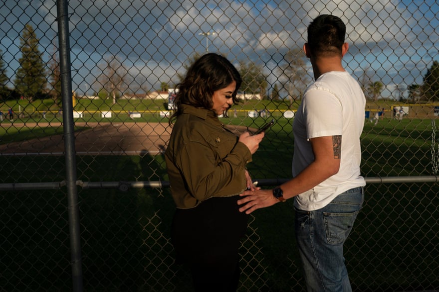 Miguel and Alexis watch their younger brother's baseball game together in Clovis, California.