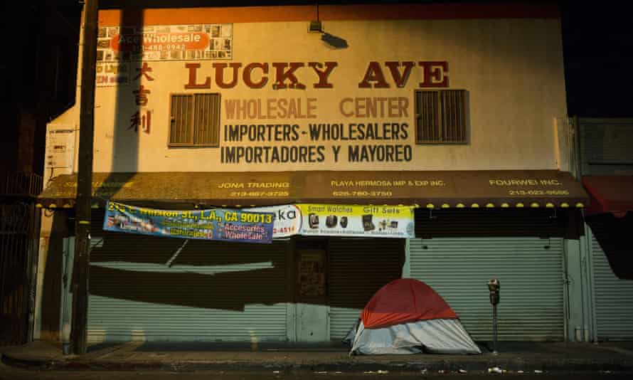 A homeless person’s tent is pitched on a sidewalk in front of the wholesale store Lucky Ave, in downtown Los Angeles.