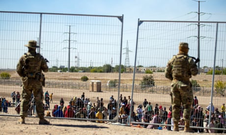 FILE - Migrants wait in line adjacent to the border fence under the watch of the Texas National Guard to enter into El Paso, Texas, Wednesday, May 10, 2023. U.S. authorities say an 8-year-old girl died Wednesday, May 17, in Border Patrol custody, a rare occurrence that comes as the agency struggles with overcrowding. The Border Patrol had 28,717 people in custody on May 10, the day before pandemic-related asylum restrictions expired, which was double from two weeks earlier, according to a court filing. (AP Photo/Andres Leighton, File)