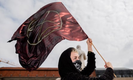 An Extinction Rebellion activist holds a flag with their symbol during a protest at the Gendarmenmarkt square in Berlin on April 27, 2019