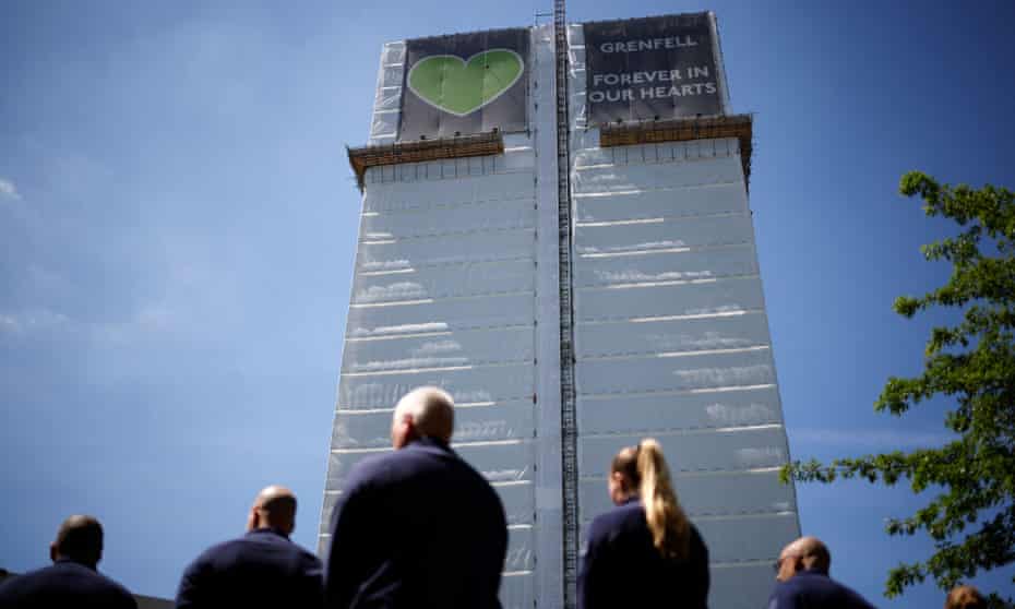 Firefighters pay their respects in June at a memorial to the victims of the Grenfell Tower fire.
