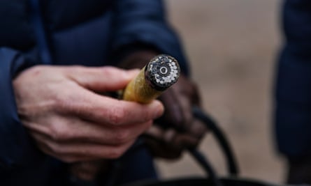 A man holds up a fibre-optic cable that has been severed to show its interior