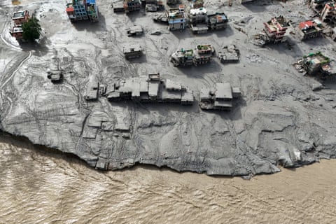Aerial view shows buildings buried in mud beside a river after flooding in Nepal