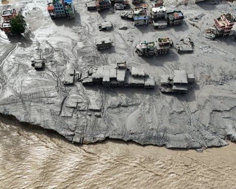 Aerial view shows buildings buried in mud beside a river after flooding in Nepal