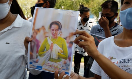 Myanmar nationals display photos of Aung San Suu Kyi during a protest against the Myanmar military coup in Bangkok, Thailand.