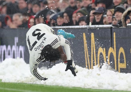 Kobbie Mainoo of Manchester United slips in the snow during against Liverpool at Anfield