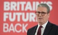 A suit and bespectacled Keir Starmer stands in front of a sign, part of which reads: 'Britain's future back'