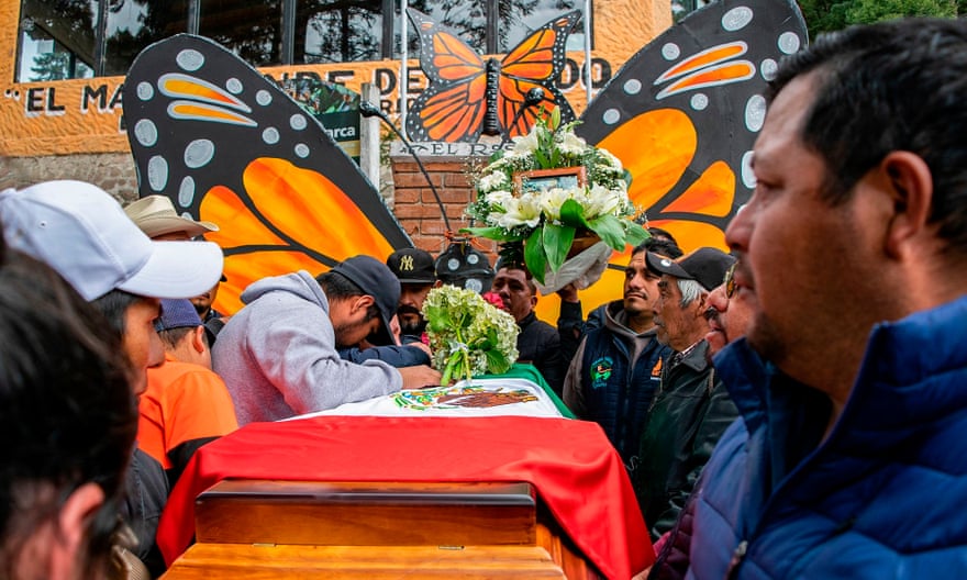 People mourn next to the coffin with the remains of Mexican environmentalist Homero Gomez, during his funeral in El Rosario village, Michoacán, on 30 January.