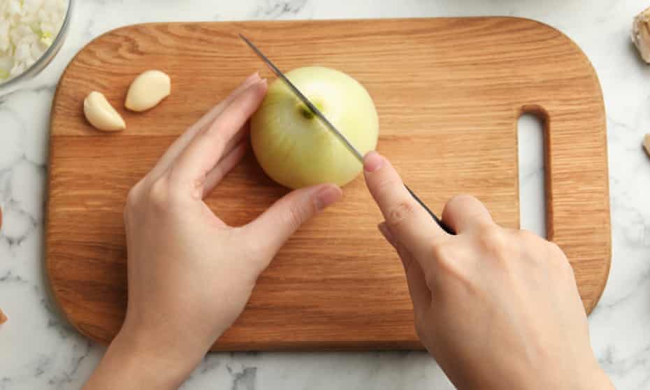 onion being chopped on board