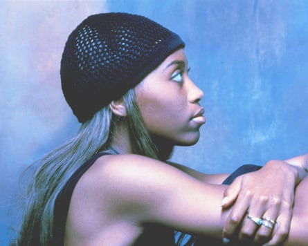 Profile photo of Rachel Wallace in a knitted beanie, resting her folded arms on her knees.