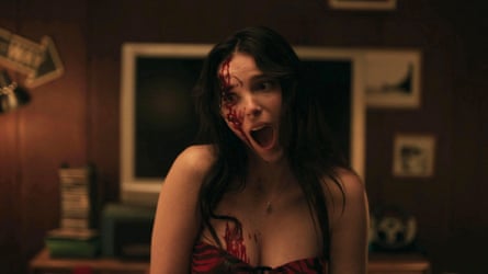 Inde Navarrette, bloodied, screams with her mouth wide open in a scene from Obsession