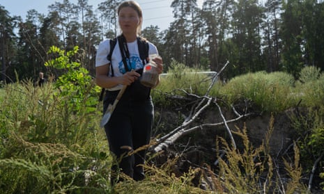 Kateryna Polyanska, an ecologist and analyst, collects a soil sample from a bomb crater outside the northern Ukrainian city of Chernihiv