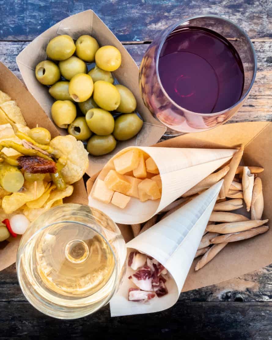 Tapas, viršus ant medinio stalo. Sūris, jamonas ir alyvuogės, raudonasis ir baltasis vynas.